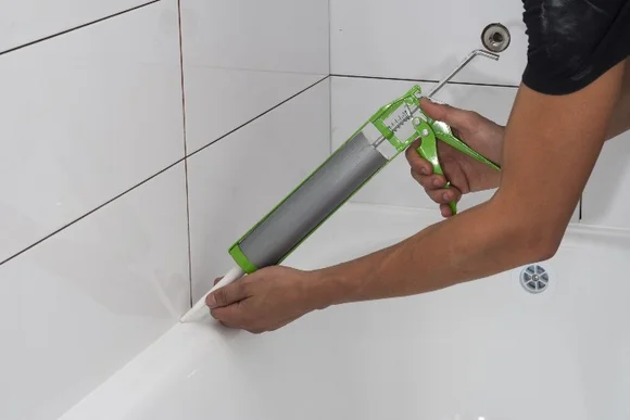 Person versiegelt Fuge mit Kartuschenpistole