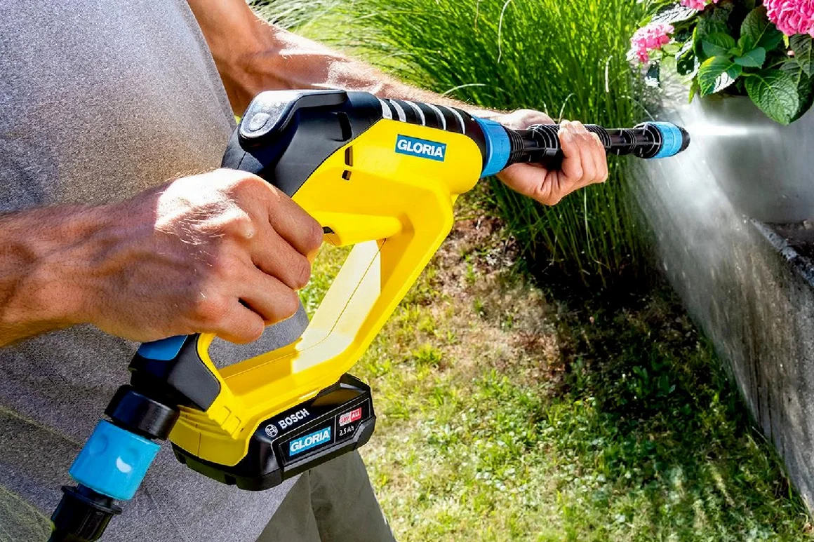 Person reinigt Steinmauer mit Hochdruckreiniger