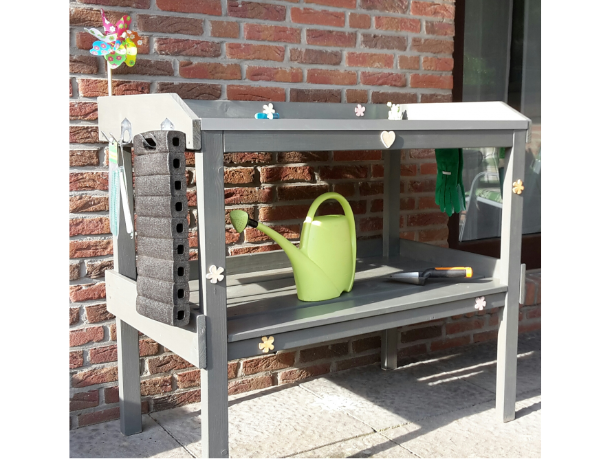 Gärtnertisch mit Gießkanne und Gartenwerkzeug