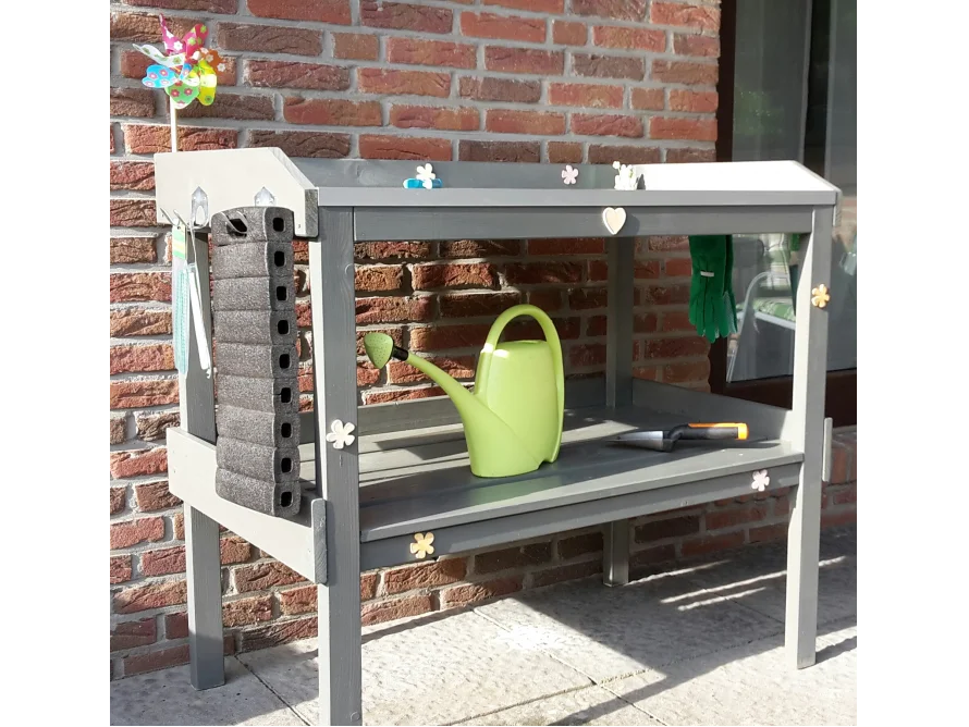 Gärtnertisch mit Gießkanne und Gartenwerkzeug
