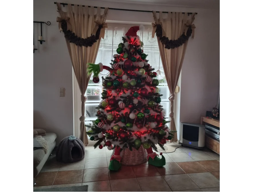 Geschmückter Weihnachtsbaum mit Elfenfüßen und roten Kugeln