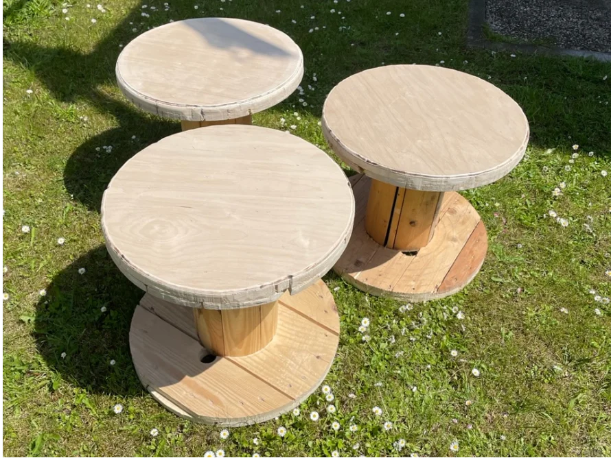 Drei runde Beistelltische aus Holz auf Rasen