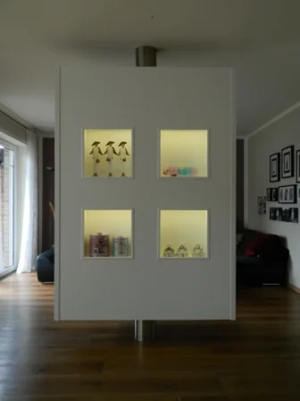 Weißer Raumteiler mit vier beleuchteten Fächern