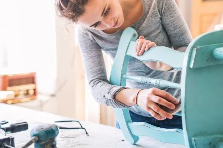 Person schleift blauen Stuhl