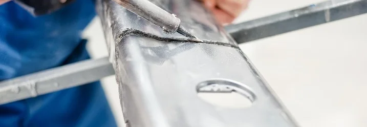 Person lötet Metallteil