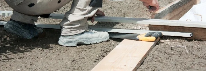 Person baut Holzgrundgerüst