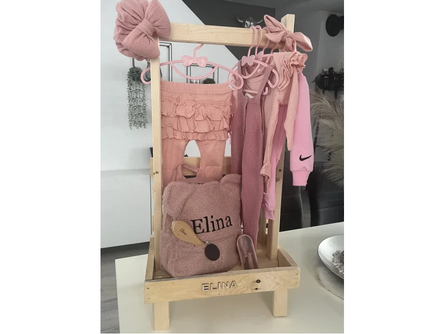 Kleiner Kleiderständer aus Holz mit Babykleidung