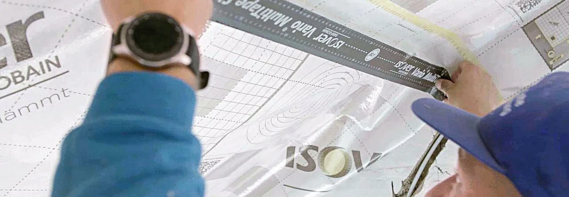 Person bringt Folie mit Maßband an