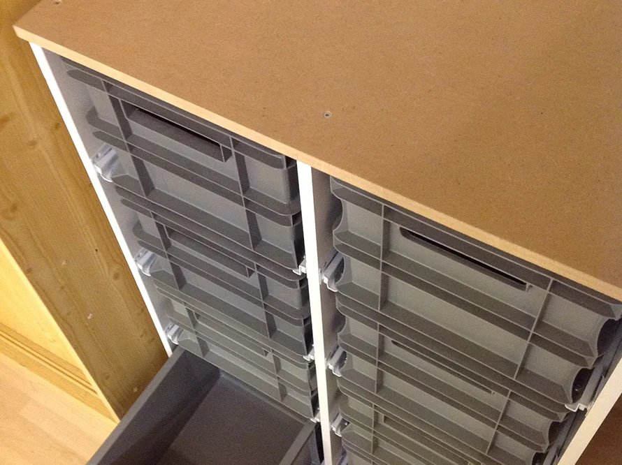 Holzregal mit grauen Schubladen