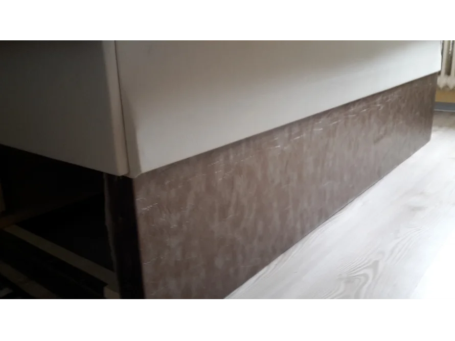 Braune Bettkante auf hellem Laminat