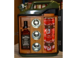 Eine grüne Metallbox mit Holzeinbauten ist geöffnet und zeigt eine Flasche und Dosen im Inneren sowie drei Gläser.