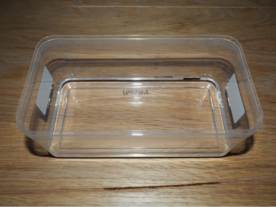 Leere durchsichtige Plastikdose auf Holztisch
