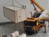 Spielzeugkran hebt Holzkiste