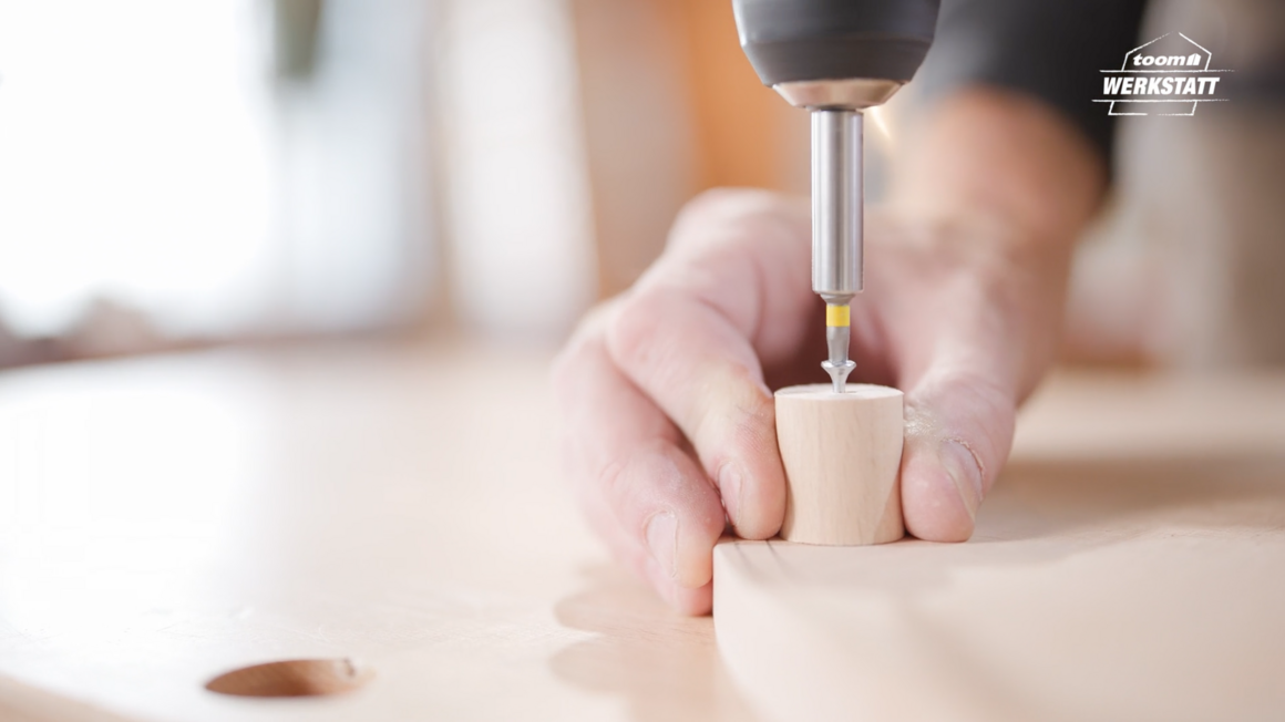 Person verschraubt Holz mit Akkuschrauber