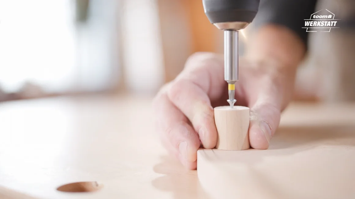 Person verschraubt Holz mit Akkuschrauber