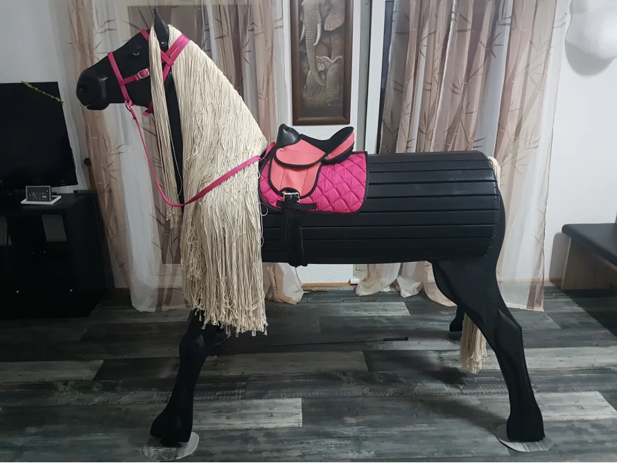 Schwarzes Holzpferd mit Sattel und Trense