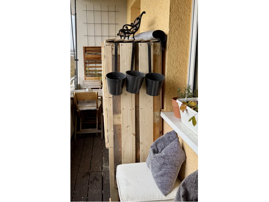 Holzgestell auf Balkon mit Blumentöpfen