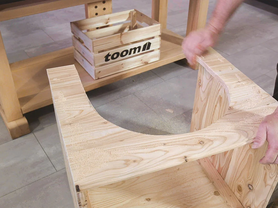 Person baut ein rundes Grundgerüst aus Holz