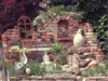 Gartenecke mit Ziegelmauer und Dekoration