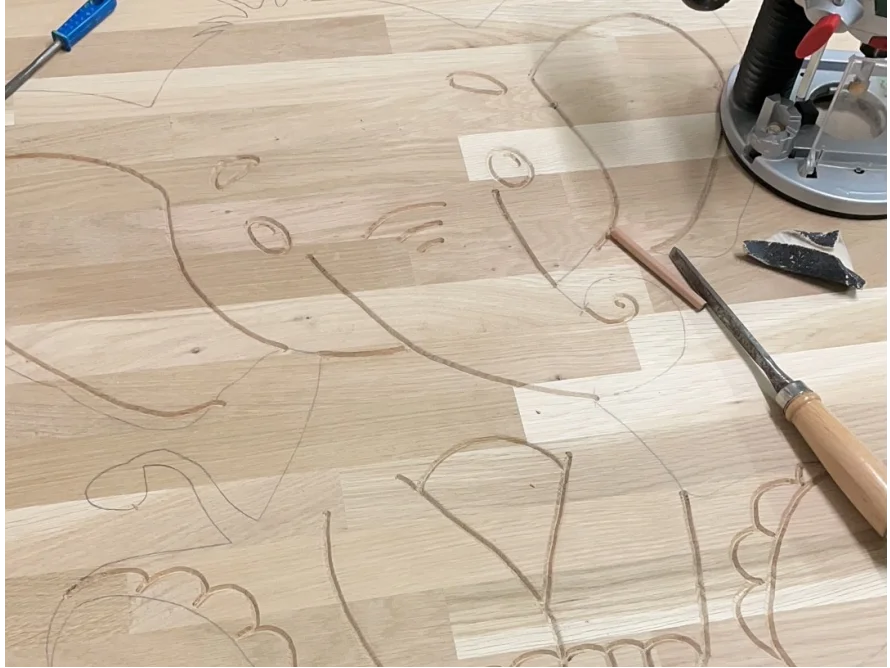 Holzplatte mit Elefantenzeichnung und Stechbeitel