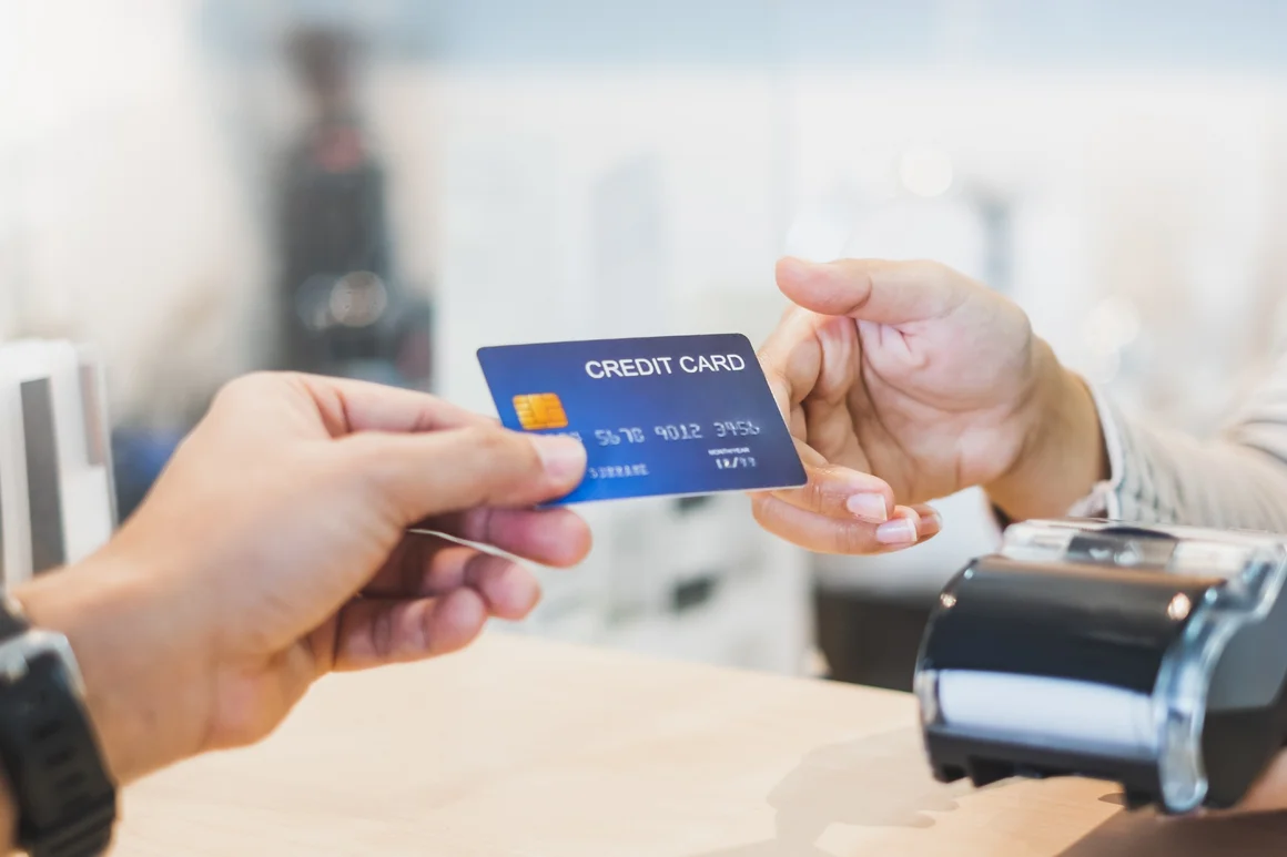 Person bezahlt mit Kreditkarte