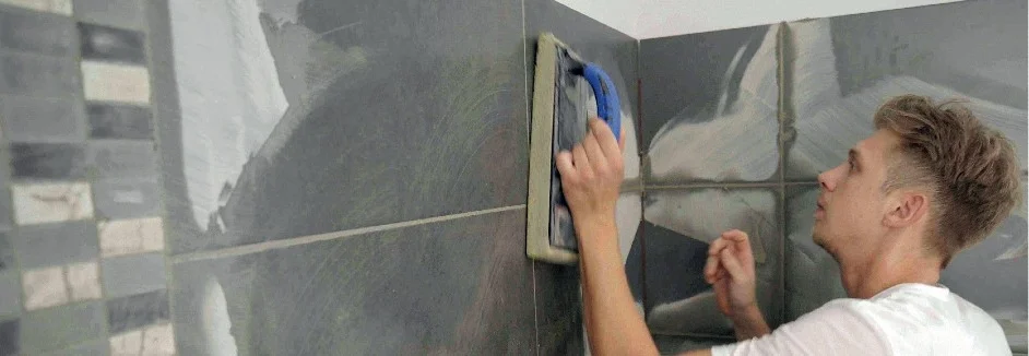 Person verfugt Fliesen