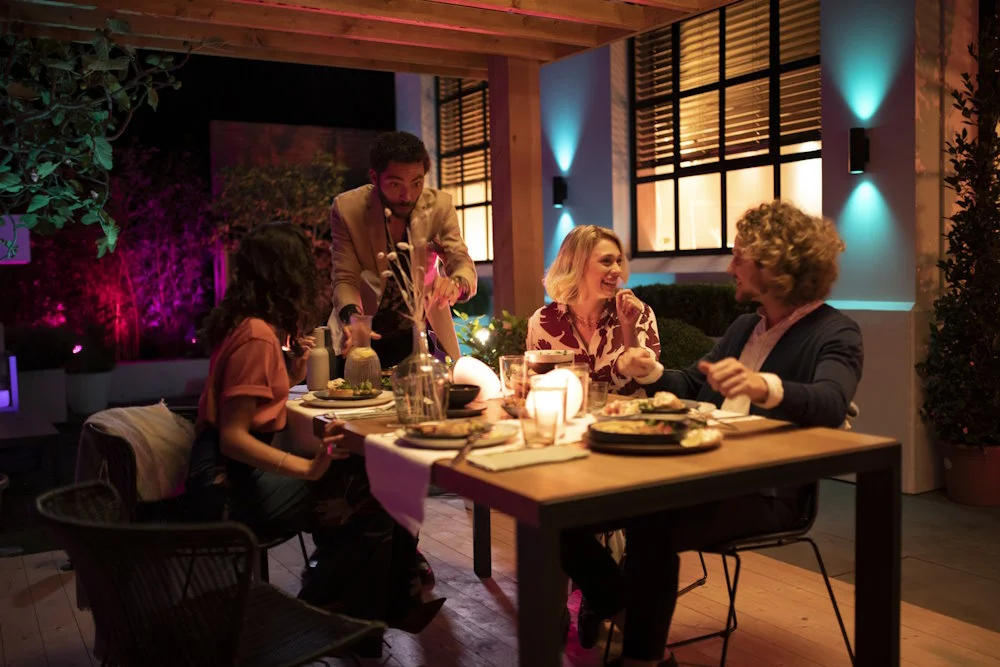 Vier Personen essen an einem Tisch im Gartenhaus