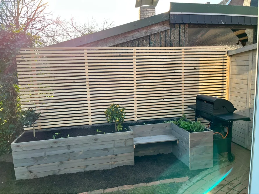 Gartenzaun aus Holz mit Hochbeeten
