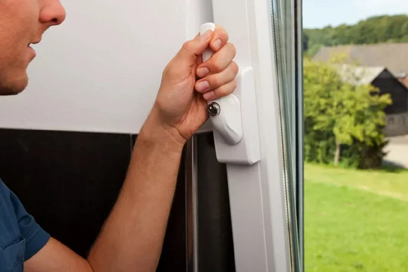 Person öffnet einen Fenstergriff.