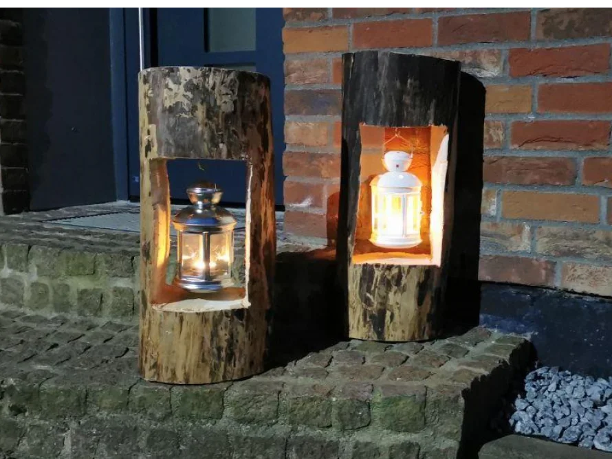 Zwei Laternen in ausgehöhlten Baumstämmen