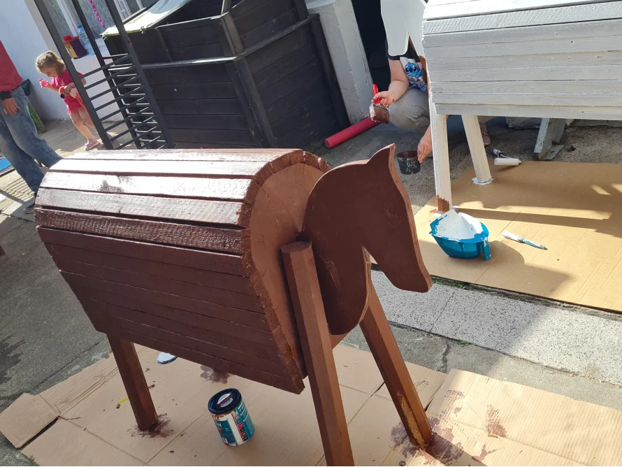 Person streicht ein Spielzeugpferd an