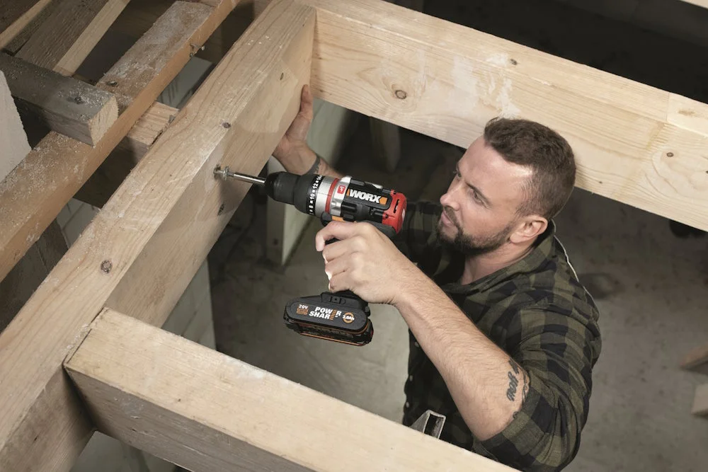 Person verschraubt Holzbalken mit Akkuschrauber