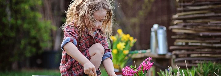 Kind pflanzt Blume ein