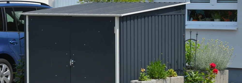 Ein graues Gartenhaus aus Metall.