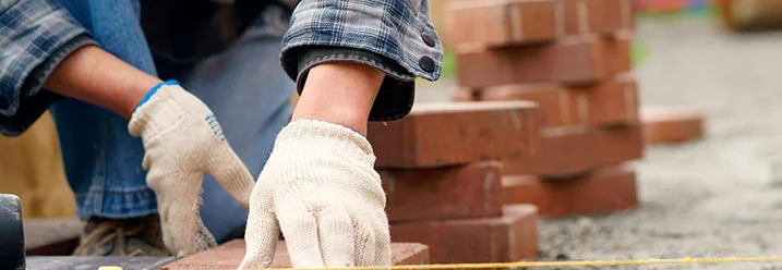 Person verlegt Pflastersteine