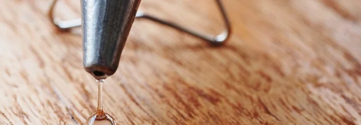 Heißklebepistole tropft auf Holz
