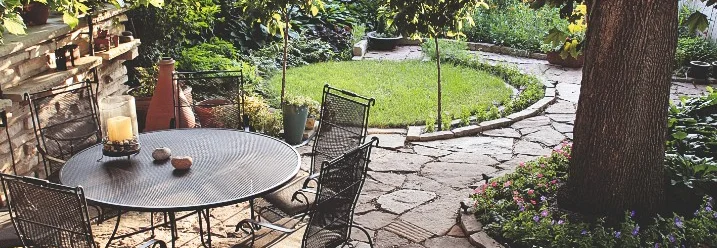 Steinterrasse mit Gartenmöbeln im Garten