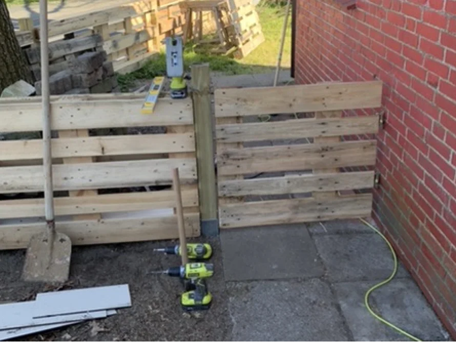 Gartenzaun aus Paletten während des Baus