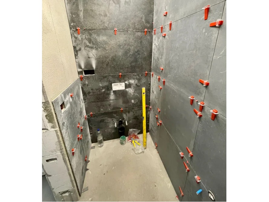 Badezimmerwand wird mit Schieferfliesen verfugt