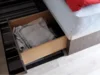 Offene Schublade unter einem Bett