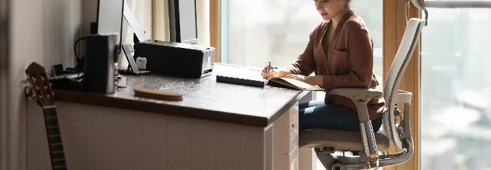 Person schreibt am Schreibtisch