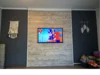 Fernseher an Holzwand mit Deko