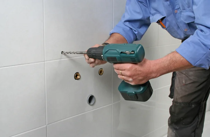 Person bohrt mit Bohrmaschine Fliesen