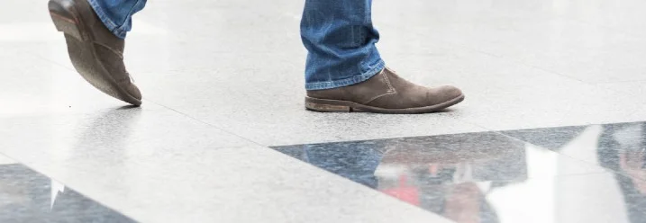 Beine einer Person mit Jeans und Schuhen