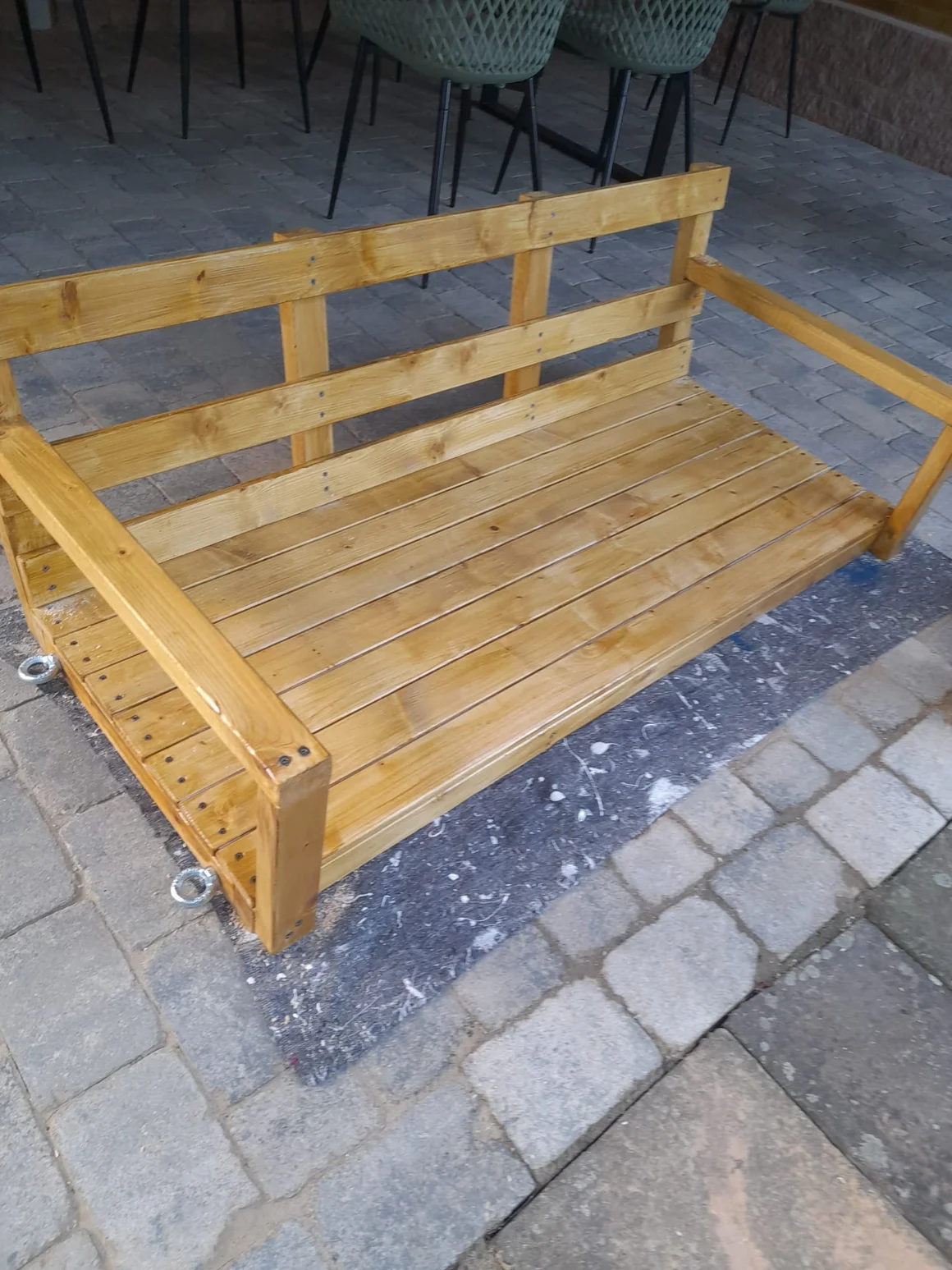 Eine selbstgebaute Hollywoodschaukel aus Holz auf einer Terrasse.