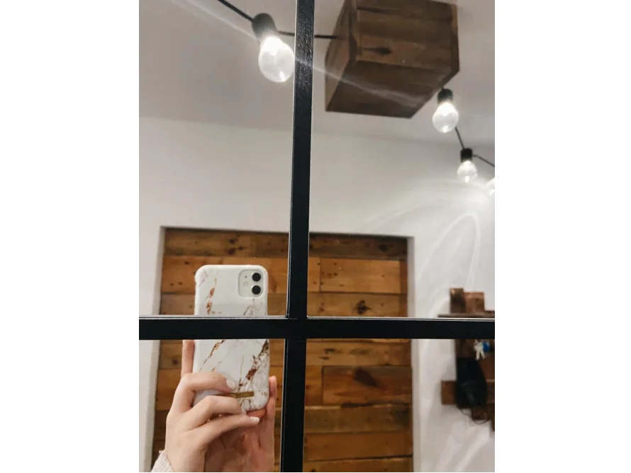 Spiegelbild einer Hand, die ein Smartphone hält