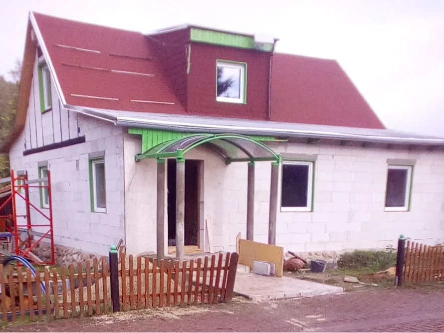Rohbau eines Einfamilienhauses mit rotem Dach