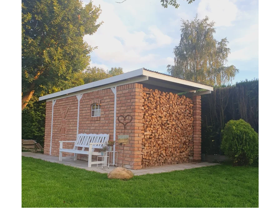 Gartenhaus aus Ziegelsteinen mit Brennholz