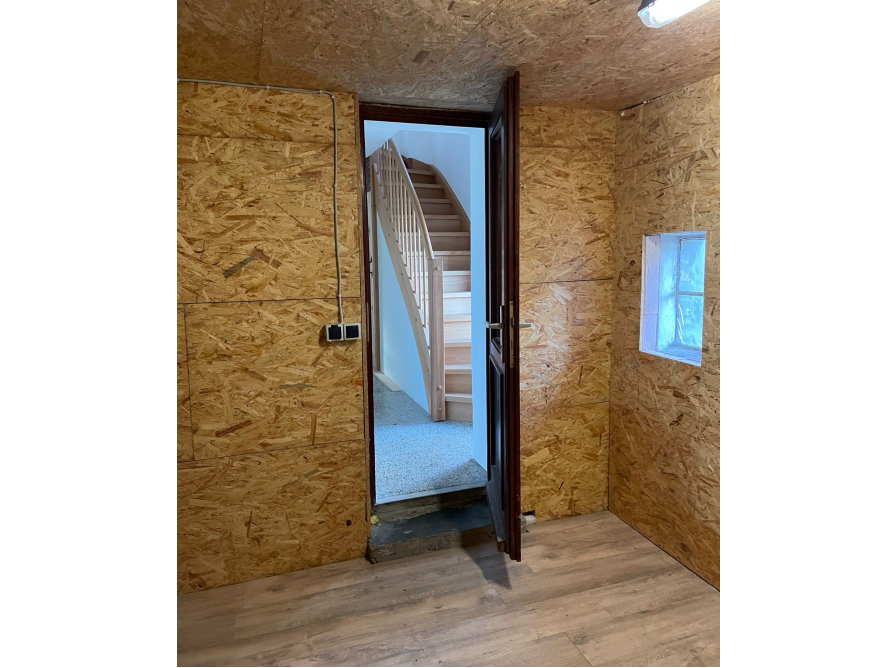 Zimmer mit Holzvertäfelung und Holztreppe