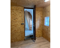 Zimmer mit Holzvertäfelung und Holztreppe